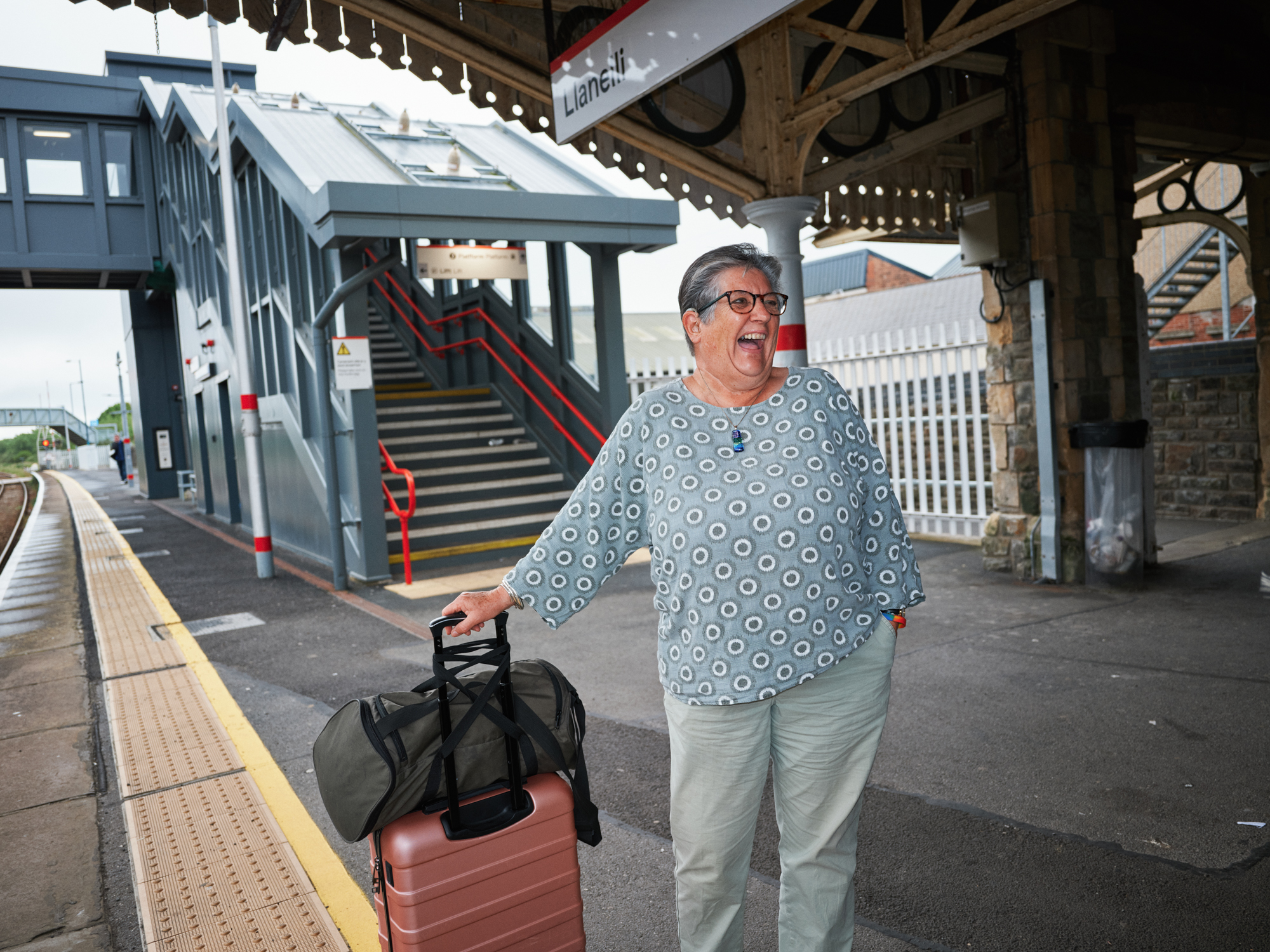 Woman with suitcase waiting at railway station