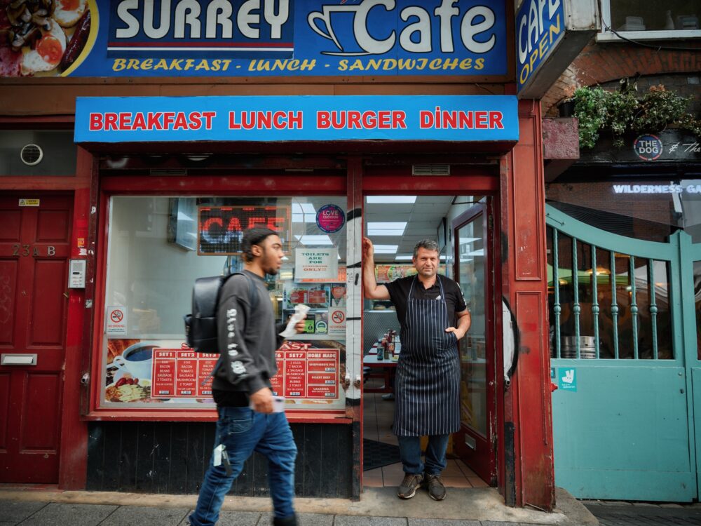 Cafe owner standing in his shop doorway