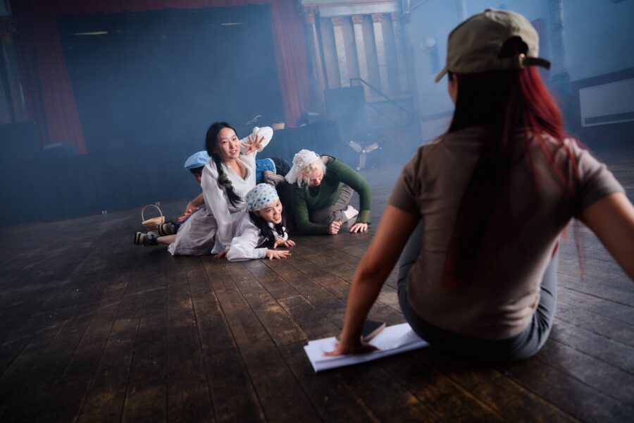 Four young people in a play rehearsal