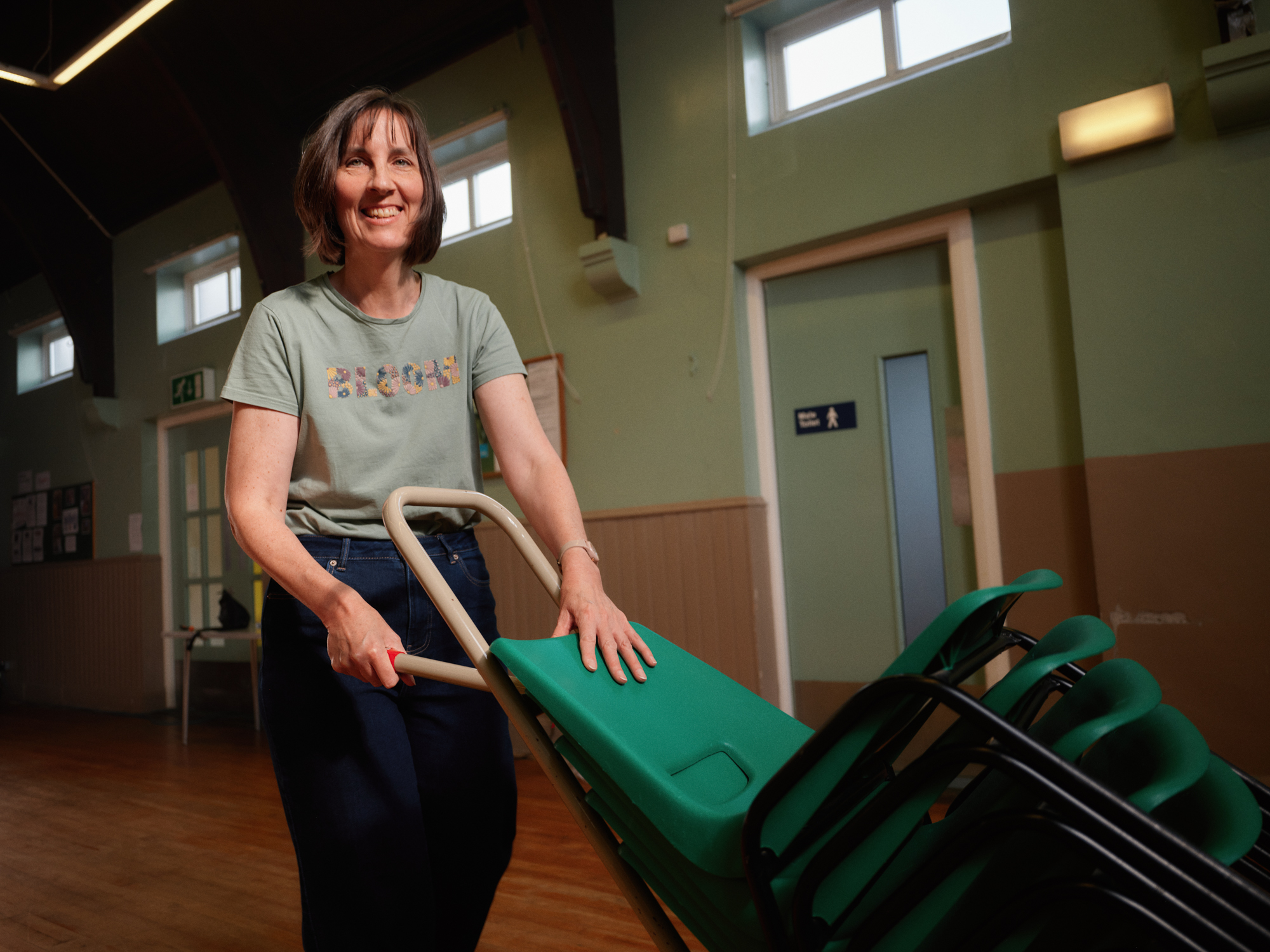 Helen, trustee of Emma Hall in Crawcrook, at work putting chairs out
