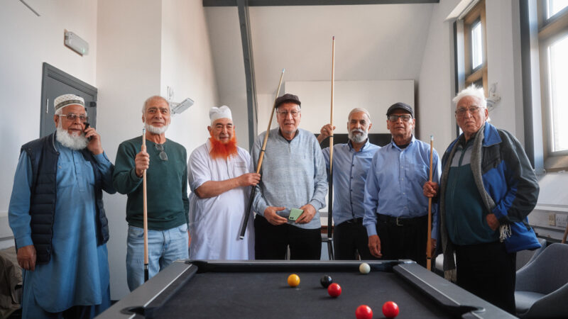 7 men at a community centre playing pool