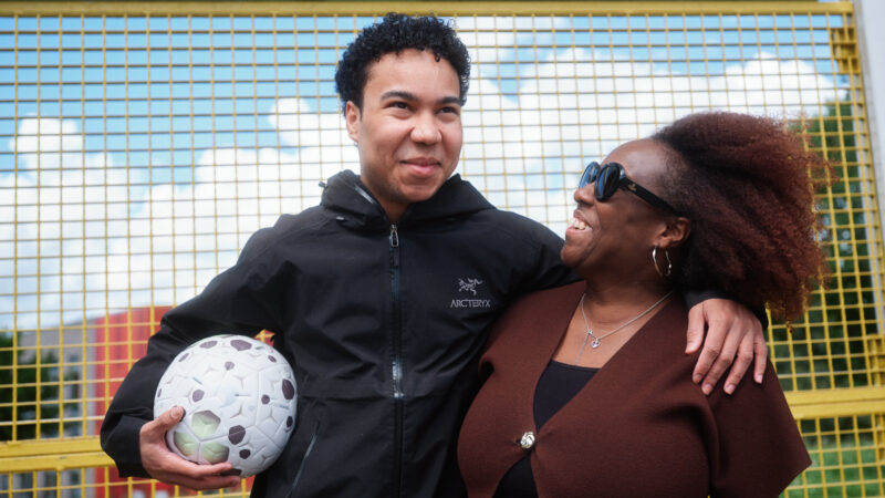 Woman and her adult son at football training