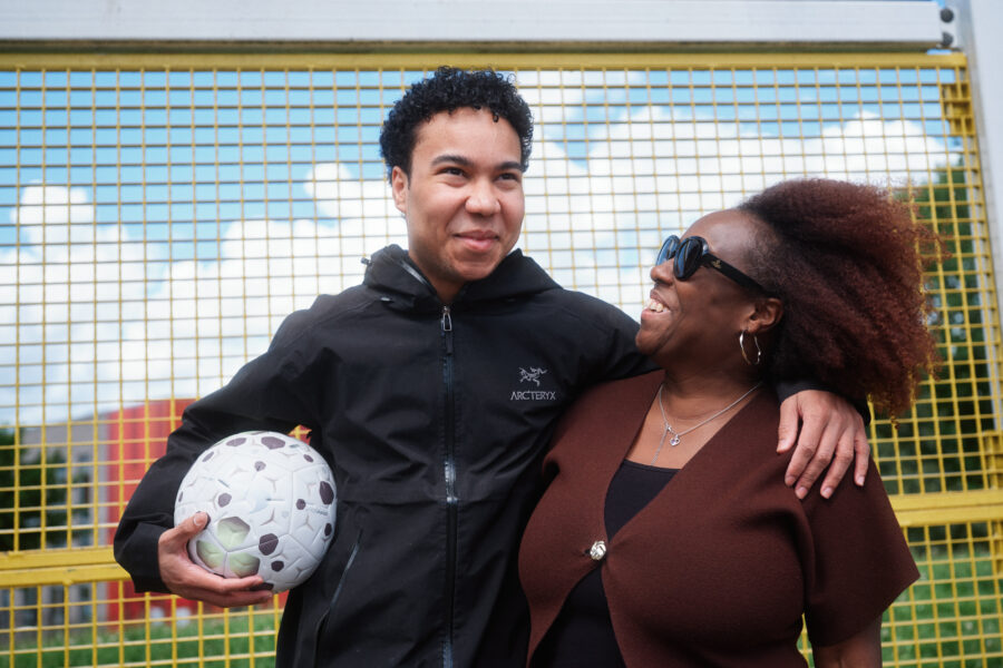 Football trainer holding a ball, with his mother