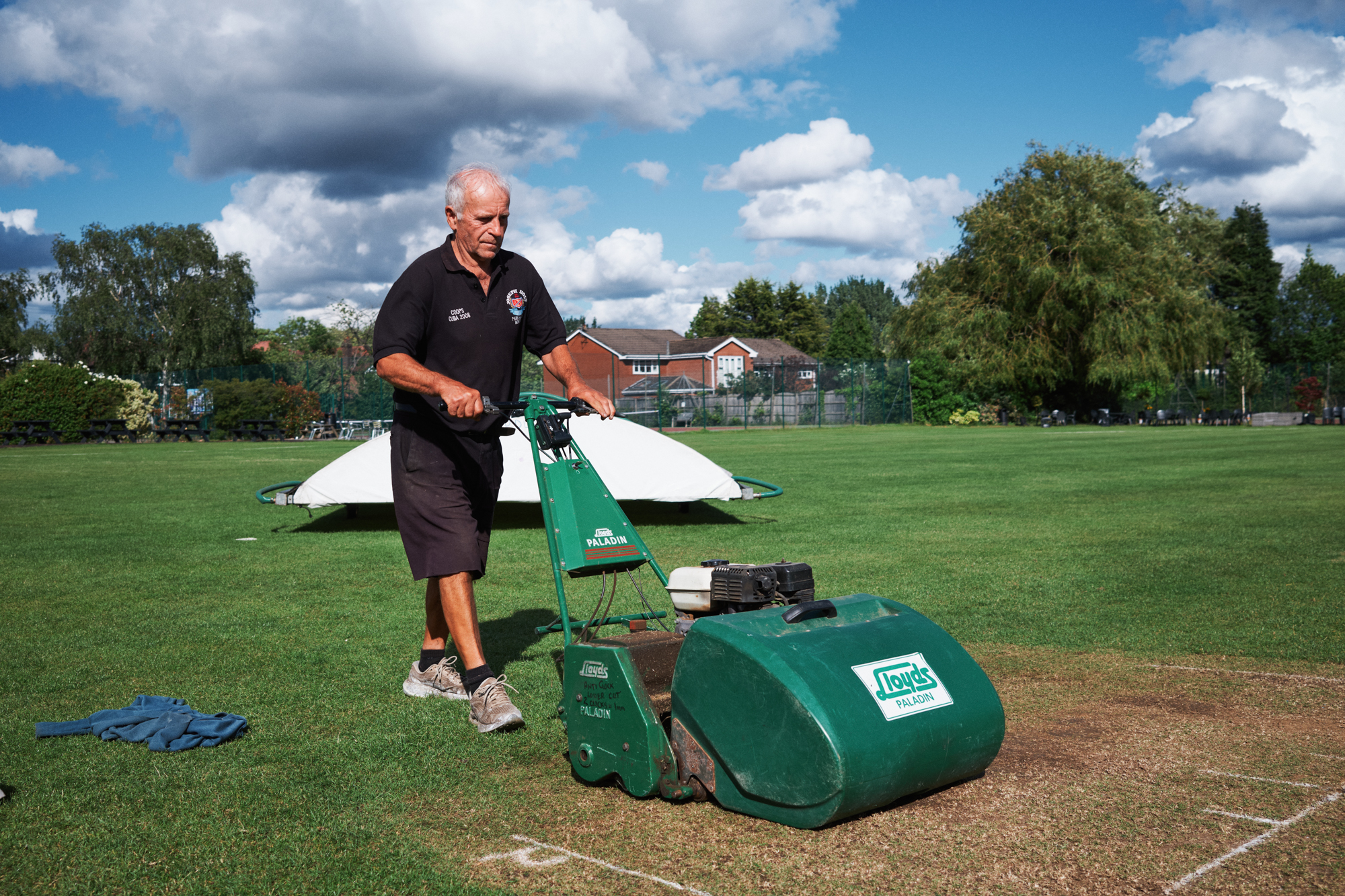 Man mowing the cricket pitch lawn